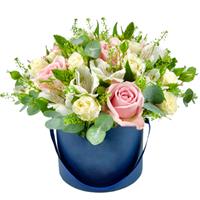 Composition of white alstroemeria and roses in a box.